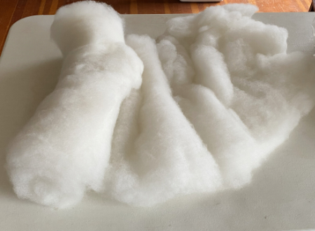 finished batt partially rolled out on a table